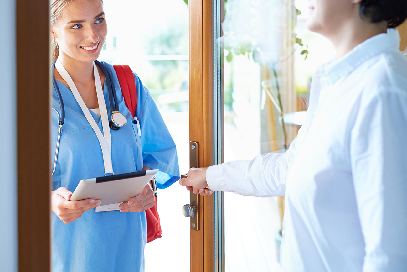 female-doctor-with-clipboard-during-home-visit-while-entering-house